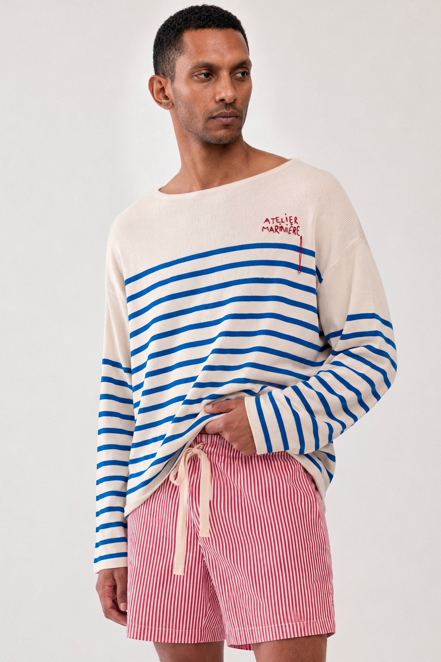 Close-up of a men's blue and white Breton shirt by Atelier Marinière featuring an oversized fit, wide boat neck and handcrafted embroidery, handcrafted in Italy from premium cotton.