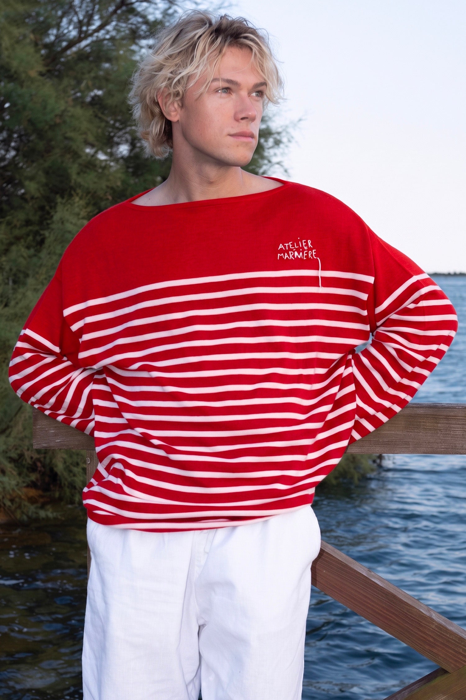 Close-up of Atelier Marinière's oversized red Breton shirt, handcrafted in Italy from premium cotton with signature hand-embroidered logo