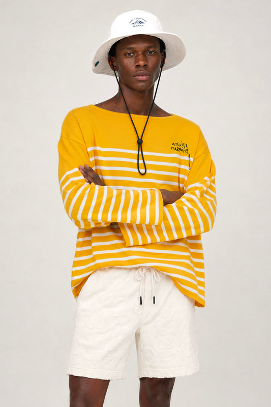 Close-up of Atelier Marinière's oversized yellow Breton shirt, handcrafted in Italy from premium cotton with signature hand-embroidered logo