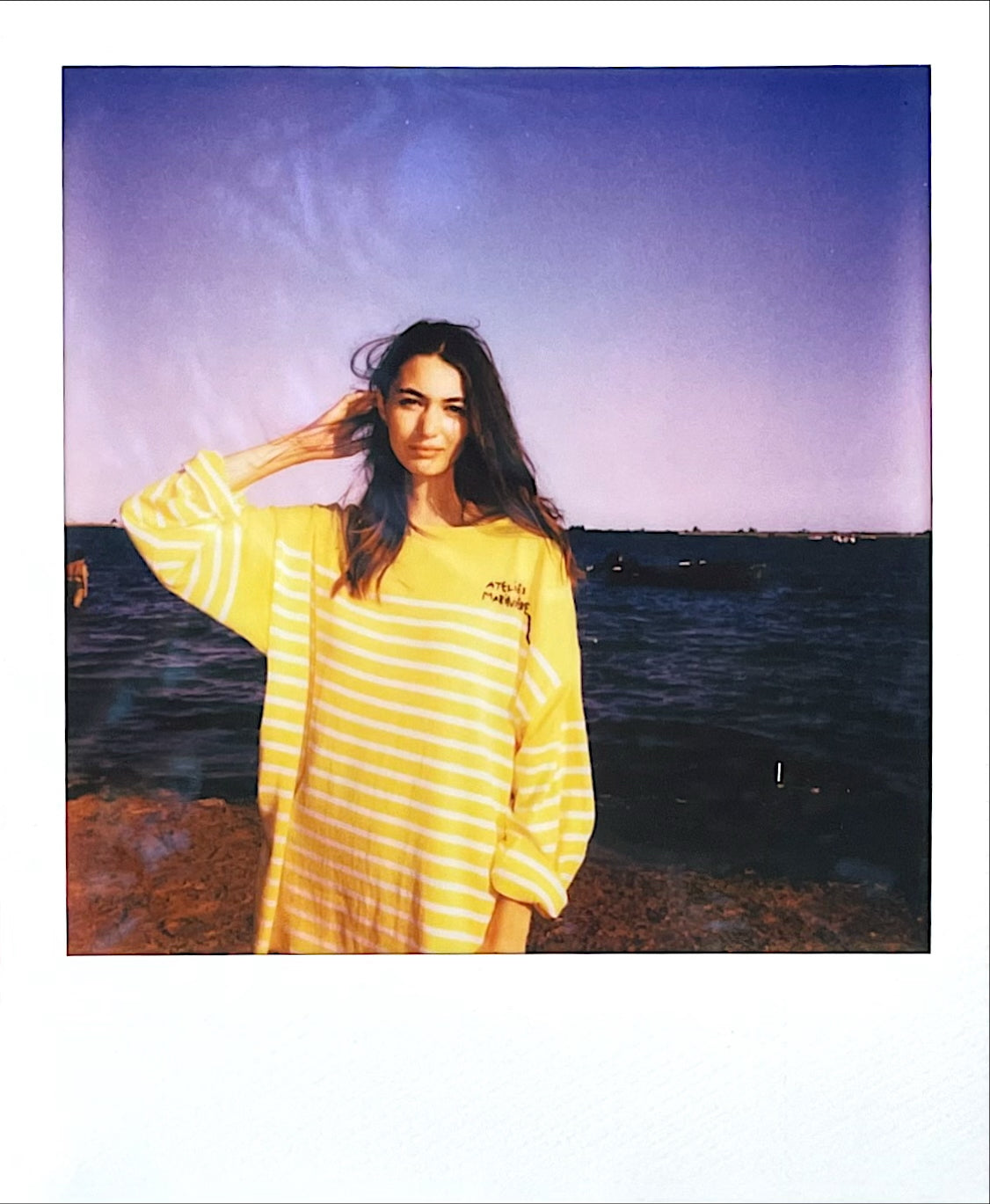 Woman wearing a yellow Atelier Marinière Breton shirt by the Venice lagoon
