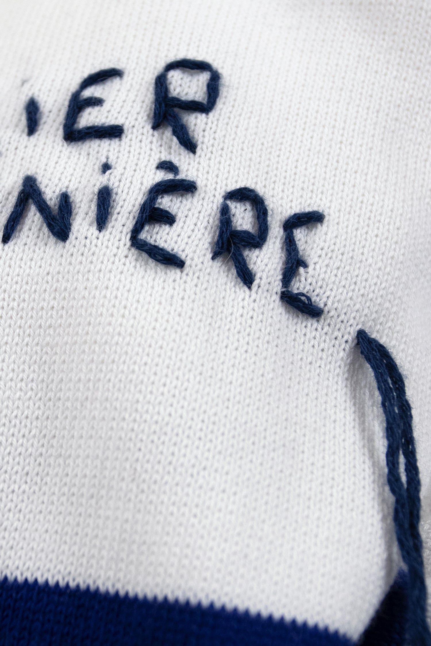 Close-up of the embroidery on the boat neck women's Breton shirt, showcasing the classic Marinière design with white and blue stripes.